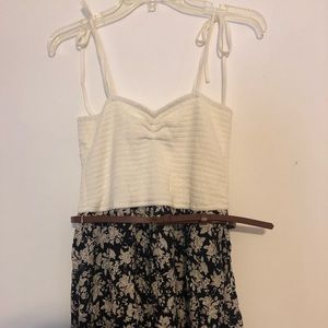 white top, blue floral bottomed dress with belt.